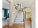 Welcoming foyer with hardwood floors, a staircase with carpet runner, and decorative artwork on the walls at 2158 Westrivers Rd, Charleston, SC 29412