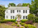 Classic two-story home with white siding, black shutters, manicured landscaping, and a welcoming front entrance at 2158 Westrivers Rd, Charleston, SC 29412