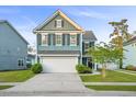 Charming two-story home with blue siding, well-manicured lawn, and attached two-car garage at 2324 Town Woods Rd, Charleston, SC 29414