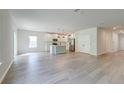 Spacious living room with light wood flooring and a view into the modern kitchen with an island at 239 Parkwood Vista Way, Summerville, SC 29486