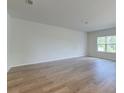 Bright and airy living room with light wood floors and a large window offering natural light and outdoor views at 239 Parkwood Vista Way, Summerville, SC 29486