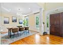 Bright dining room with wood floors, chandelier, tray ceiling, wainscoting, and natural light at 3101 S Shore Dr, Charleston, SC 29407