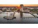 Aerial view of the property and adjacent harbor with yachts and surrounding city buildings during a beautiful sunset at 330 Concord St # 2F, Charleston, SC 29401