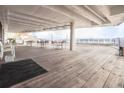 Open-air deck with multiple tables and chairs, a wooden floor, and a partial view of the surrounding landscape at 330 Concord St # 2F, Charleston, SC 29401