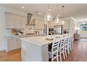 This kitchen boasts an island with seating, pendant lighting, stainless steel appliances, and hardwood floors at 3585 Sawlog Dr, Summerville, SC 29486