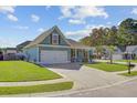 Blue home with a spacious driveway, well-kept lawn, and charming curb appeal in a residential neighborhood at 3801 Canary Ct, North Charleston, SC 29420