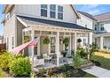 Inviting front porch with comfortable seating, hanging plants, and a charming porch swing at 383 Oak Park St, Summerville, SC 29486