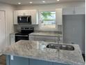 Close up of the kitchen island featuring granite countertops and stainless steel sink at 4626 W W Montague Ave, North Charleston, SC 29418