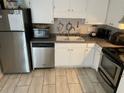 Cozy kitchen with stainless steel appliances, white cabinets, and light tile flooring at 4652 Nibbs Ln, North Charleston, SC 29418