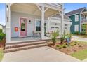 Inviting front porch featuring a seating area, a pink door, and a well-manicured garden at 503 Ivy Green Ln, Summerville, SC 29486