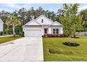 Beautiful one-story home boasting lush green lawns, palm tree, and clean white exterior with pink front door at 512 Pontoon Rd, Huger, SC 29450