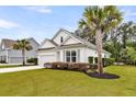 Picture of a well-manicured lawn of a white single-story home, with a bright pink front door, and palm trees at 512 Pontoon Rd, Huger, SC 29450