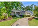 A home with an arched entryway, a circular driveway, and professional landscaping at 5433 Clearview Dr, North Charleston, SC 29420