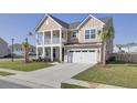 Charming two-story home featuring a welcoming front porch, two car garage and nicely kept lawn at 661 Black Pine Rd, Moncks Corner, SC 29461