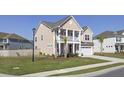 Charming two-story home featuring a welcoming front porch, two car garage and freshly manicured lawn at 661 Black Pine Rd, Moncks Corner, SC 29461