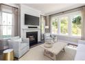 Bright living room with a fireplace, large windows, and stylish decor at 784 Clay Field Trl, Summerville, SC 29485