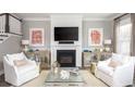 Inviting living room with a cozy fireplace, white seating, and stylish decor at 786 Clay Field Trl, Summerville, SC 29485