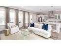 Bright and airy living room open to the kitchen, featuring a plush white sofa and ample natural light at 786 Clay Field Trl, Summerville, SC 29485