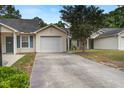 Exterior of home featuring a driveway and attached garage, complemented by lush greenery at 7896 Montview Rd, North Charleston, SC 29418
