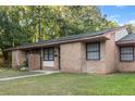 Charming single-story brick home featuring a well-maintained lawn and mature trees at 7914 Dutch Ct, North Charleston, SC 29420