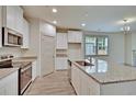 Bright kitchen features granite counters, stainless steel appliances, a spacious island, and ample cabinetry at 8633 Connor Ct, North Charleston, SC 29406