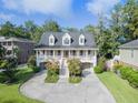 Charming two-story home with a traditional design, front porch, and landscaped front yard at 8657 Refuge Point Circle Cir, Charleston, SC 29420