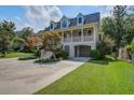 Charming two-story home with a spacious driveway, two-car garage, and inviting front porch at 8657 Refuge Point Circle Cir, Charleston, SC 29420