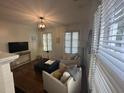 Inviting living area with white armchairs, a dark blue ottoman, hardwood floors, and natural light at 9 West St # 1, Charleston, SC 29401