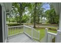 Cozy covered front porch with white railings offering a view of the well-maintained lawn and street at 987 Harbor Oaks Dr, Charleston, SC 29412
