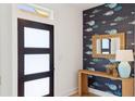 Stylish entryway featuring a modern door, unique wallpaper, and a charming accent table with decor at 1014 E Erie Ave, Folly Beach, SC 29439