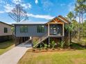 Beautiful home with modern design, metal roof, and lush landscaping offering curb appeal at 1014 E Erie Ave, Folly Beach, SC 29439