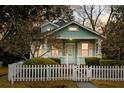 Charming green home with a white picket fence and beautifully landscaped front yard at 103 Tall Oak Ave, Charleston, SC 29407