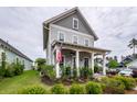 Charming two-story home with gray siding, inviting front porch, and manicured landscaping at 107 Clear Bend Ln, Summerville, SC 29486