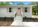 Close-up of a recently updated entryway to a brick home with a painted pink door and refreshed trim at 1109 Hillside Dr, Charleston, SC 29407