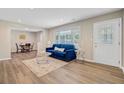 Bright living room featuring hardwood floors, a blue couch, and large windows at 113 Harvey Ave, Goose Creek, SC 29445