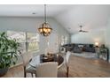 Bright dining area with a contemporary chandelier, wood floors, and comfortable seating adjacent to the living room at 1136 Peninsula Cove Dr, Charleston, SC 29492
