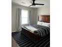 Cozy bedroom with a large dark wood bed, neutral walls, and stylish black striped rug at 117 Fripp Ln, Summerville, SC 29483