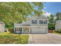 Charming two-story home with gray siding, blue shutters, an attached garage and a well-maintained lawn at 122 Balsam Cir, Summerville, SC 29485