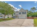 Charming two-story home featuring gray siding, blue shutters, an attached garage and a well-maintained lawn at 122 Balsam Cir, Summerville, SC 29485