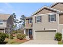 Charming two-story townhouse with an attached garage, tidy landscaping, and a welcoming paved driveway at 153 Wild Holly Dr, Moncks Corner, SC 29461