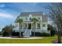 Stately two-story white home with palm trees, grand staircase, fountain, and a beautifully landscaped circular driveway at 1531 Murphys Island Ct, Awendaw, SC 29429