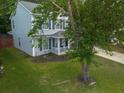Angle view of a home with a well-maintained lawn, mature tree, and driveway at 186 Two Pond Loop, Ladson, SC 29456