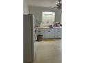 Functional kitchen with white cabinets, ample counter space, and vintage-style flooring, ready for modernization at 2066 Maybank Hwy, James Island, SC 29412