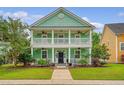 Welcoming two-story home with double porches, complemented by lush landscaping and a manicured lawn at 209 Forsythia Ave, Summerville, SC 29483
