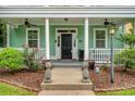 Inviting front porch with columns, ceiling fans, and pineapple decor at 209 Forsythia Ave, Summerville, SC 29483