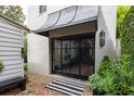 Stylish black framed glass back door with brick landing and modern awning at 21 1/2 Pitt St, Charleston, SC 29401