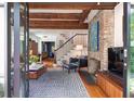 Inviting living room featuring a brick fireplace, exposed beams, and an open view to the home's entryway at 21 1/2 Pitt St, Charleston, SC 29401
