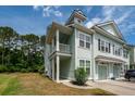 Bright townhome with a covered porch, green lawn, and an attached garage on a sunny day at 2119 Oyster Reef Lane Ln, Mount Pleasant, SC 29466