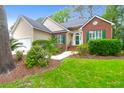 Inviting home featuring a brick facade, neutral siding, green shutters and lush landscaping at 2520 Woodstream Rd, Mount Pleasant, SC 29466