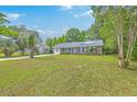 Beautifully landscaped front yard showcasing a single-story brick home with a light blue front door and shutters at 2534 Flamingo Dr, Charleston, SC 29414